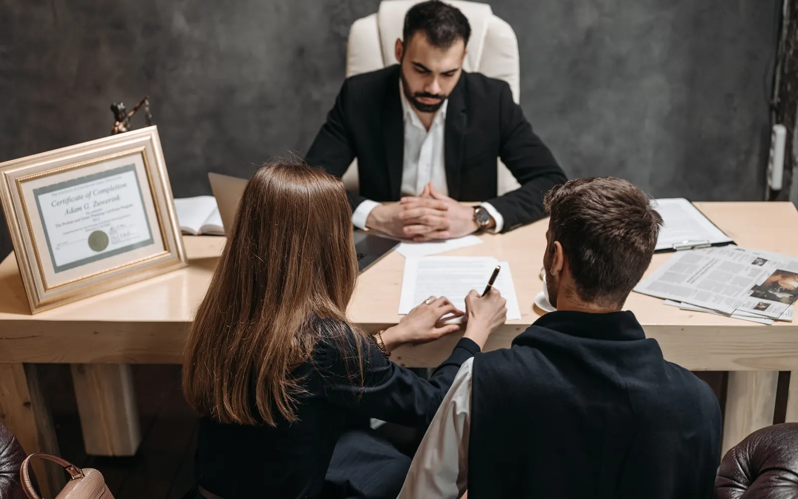 Attorney meeting with clients to review legal documents in an office