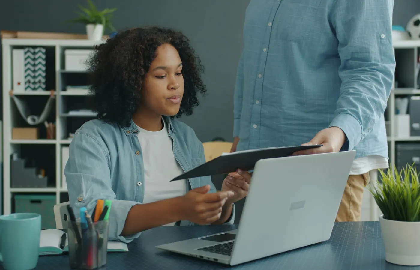 Law firm team member sharing a case file beside a laptop